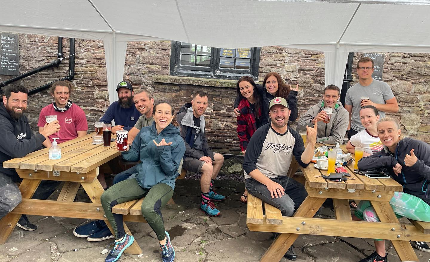 Un grupo de excursionistas y personas sentadas en las mesas fuera del Skirrid Mountain Inn en Avergavenny, Gales