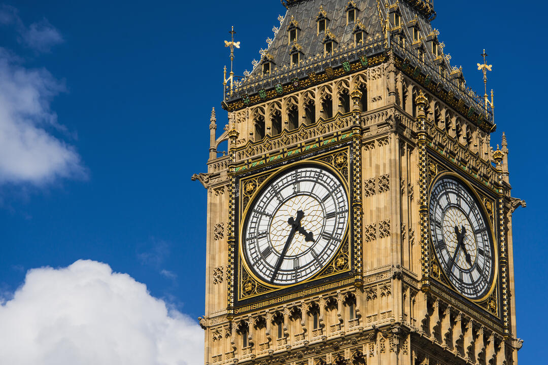 Close up view of the ornate clock face on a bright sunny day.
