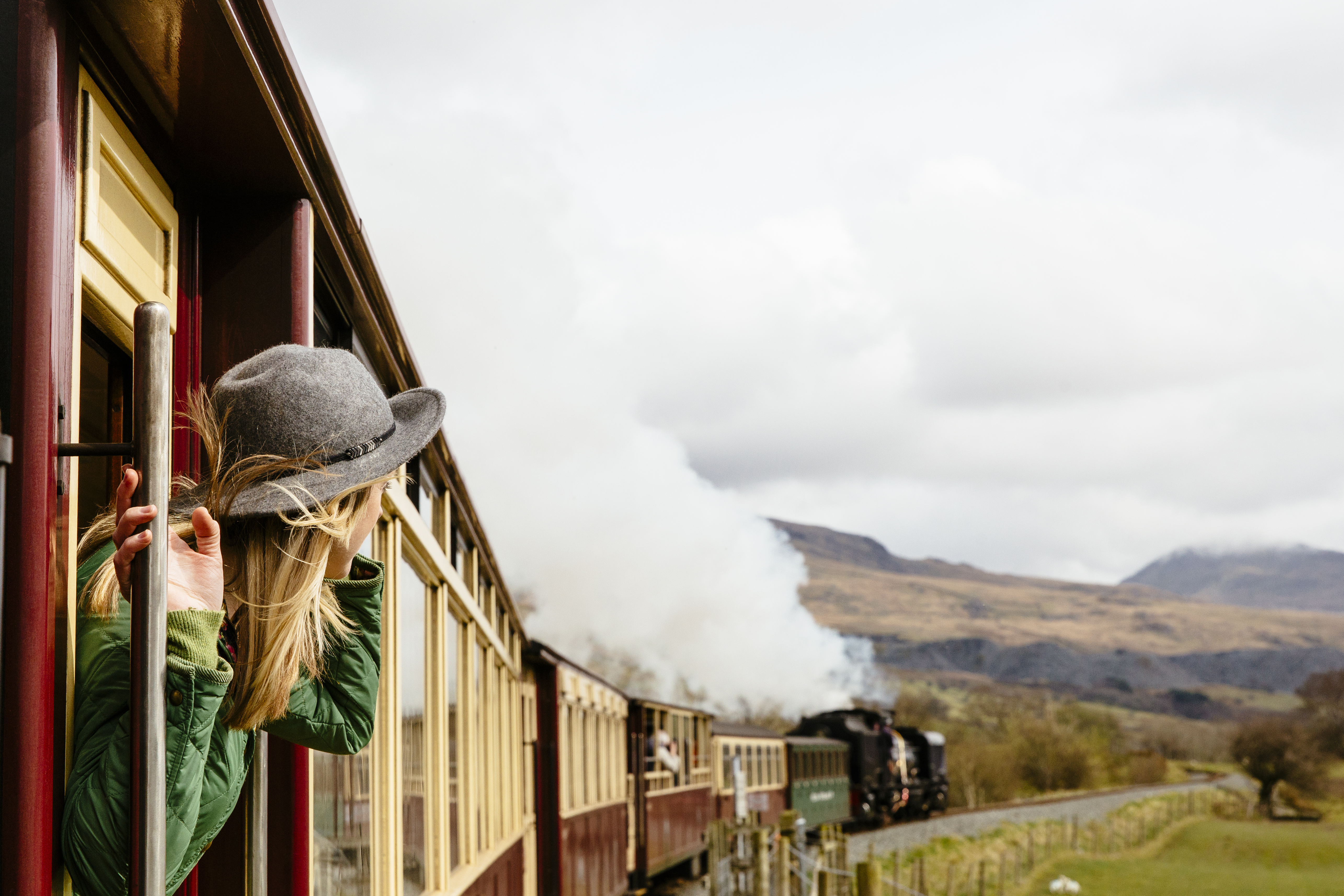 Woman looking out of window of traditional railway train
