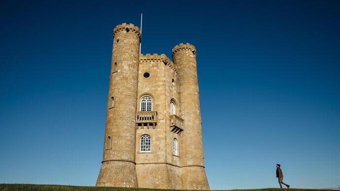 Un homme marchant vers une tour à tourelles.