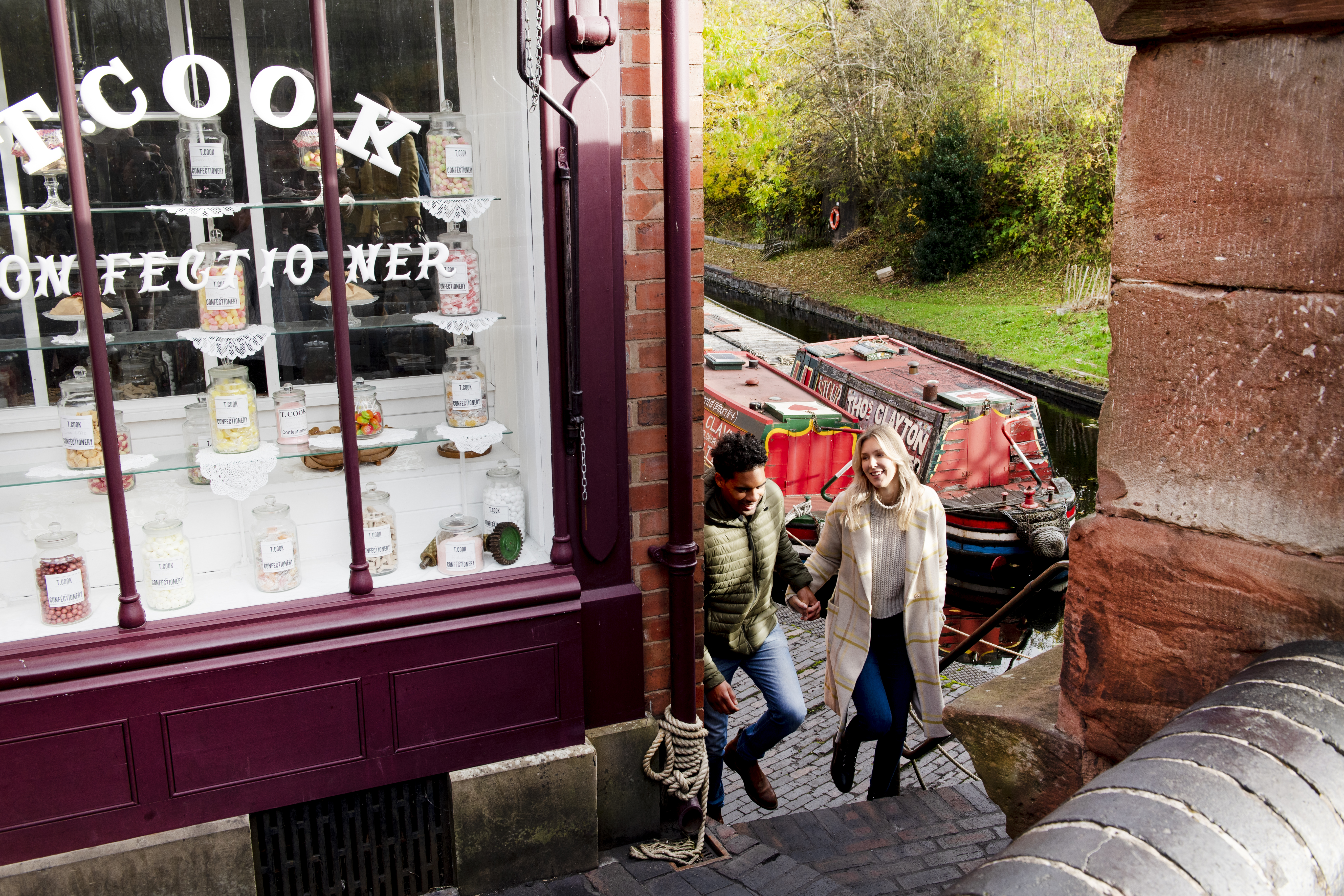 Couple walking up steps by the side of a sweet shop and canal