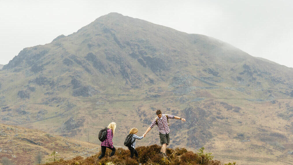 Man, woman and a child walking in the mountains