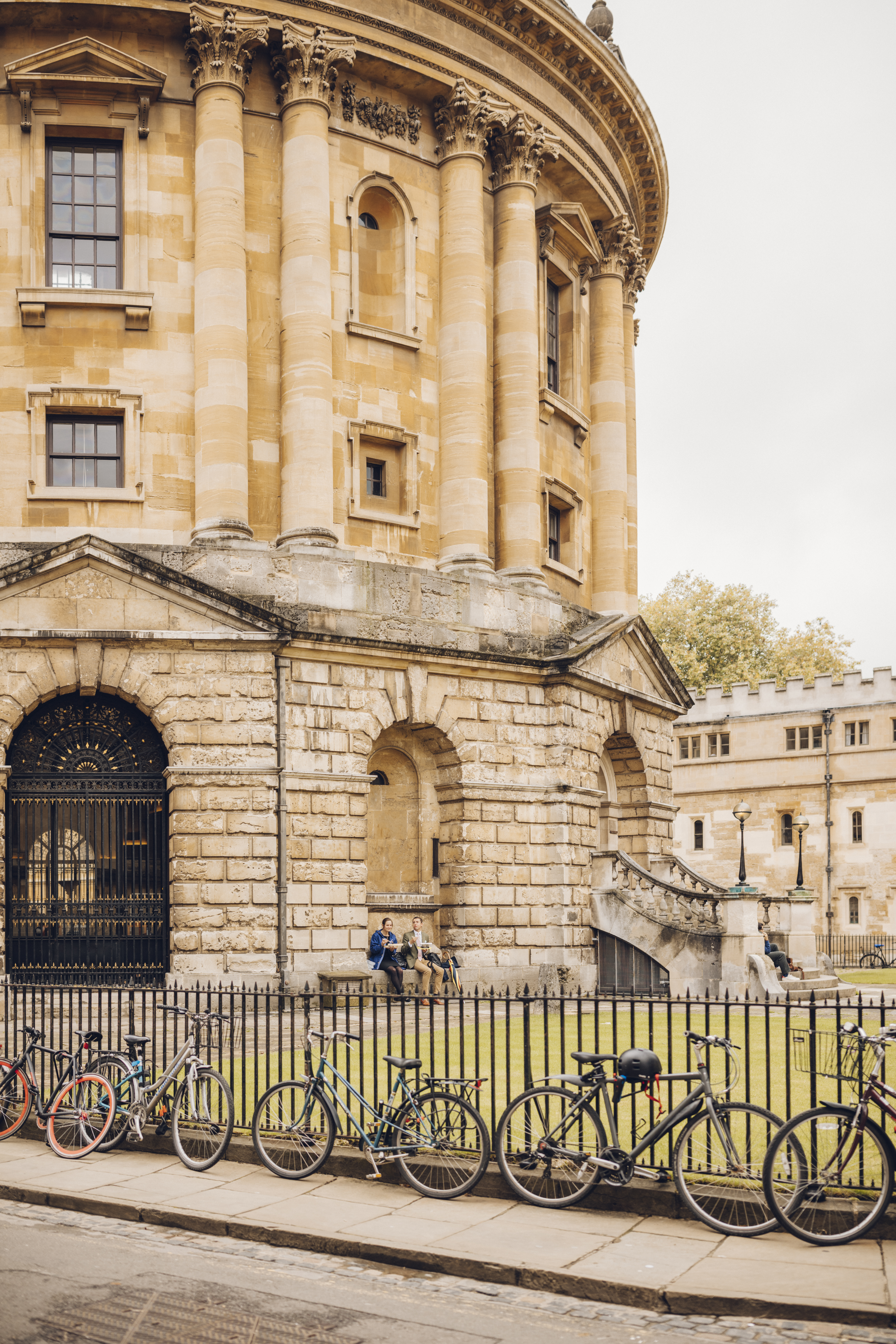 شخصان يجلسان تحت قوس خارج مبنى تاريخي