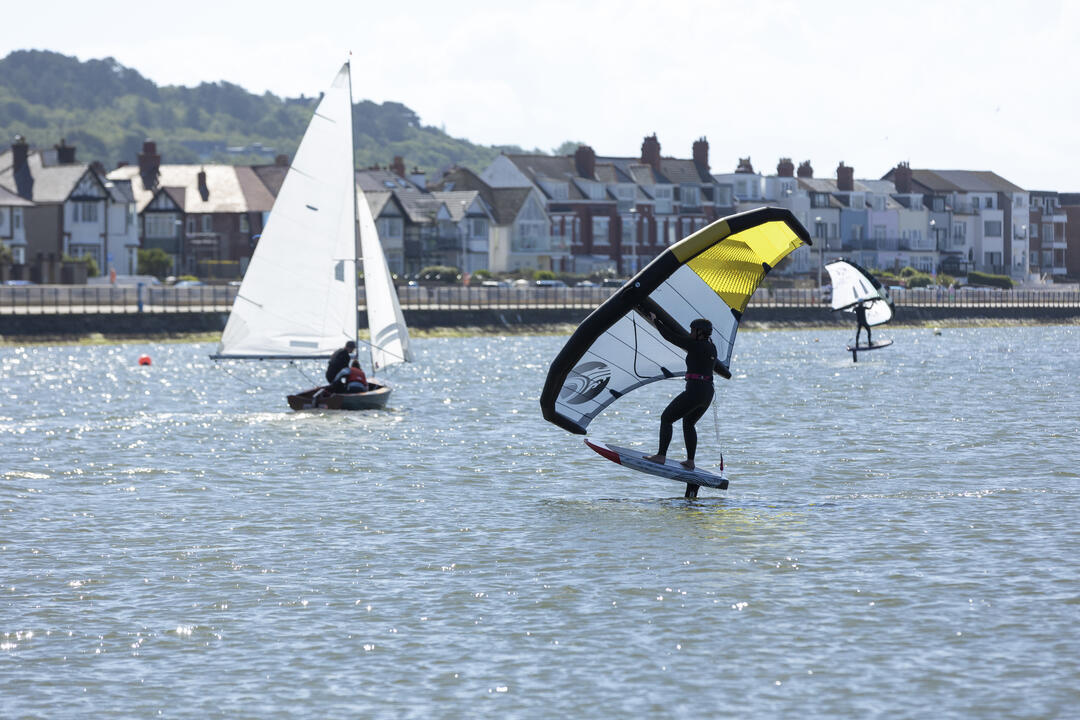 Wingfoiling and sailing on a saltwater marine lake on a sunny day
