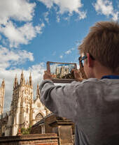 Un garçon photographiant la cathédrale de Canterbury avec sa tablette numérique