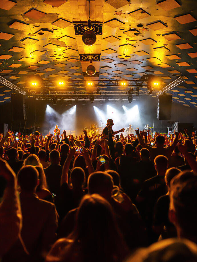 Fiesteros disfrutando del baile en una sala de música y salón de baile.