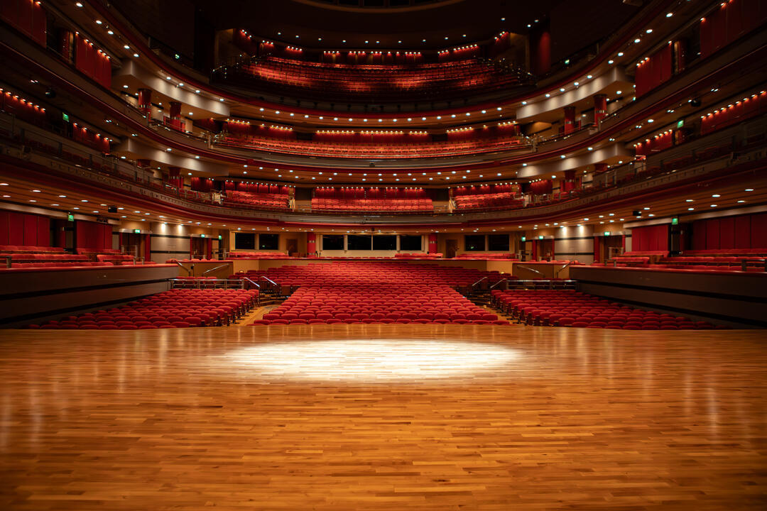 Inside view of a large empty music hall and it's stage.