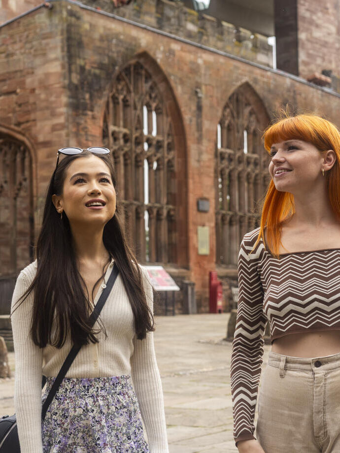 Two women explore the ruins within the grounds of a Cathedral