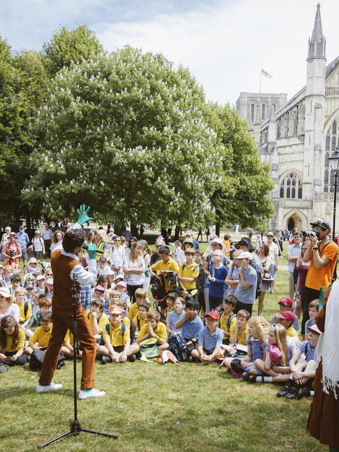 Performance in front of an audience on a lawn near cathedral