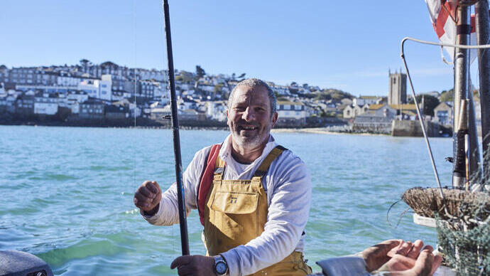 Pescatore su una barca da pesca in mare