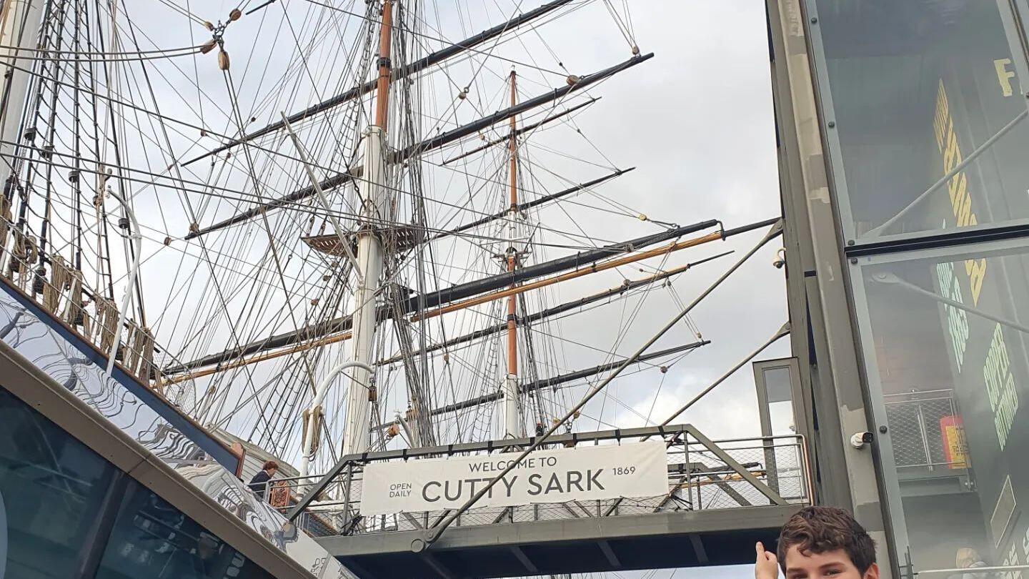 Un bambino in posa fuori dal Cutty Sark a Greenwich, Londra