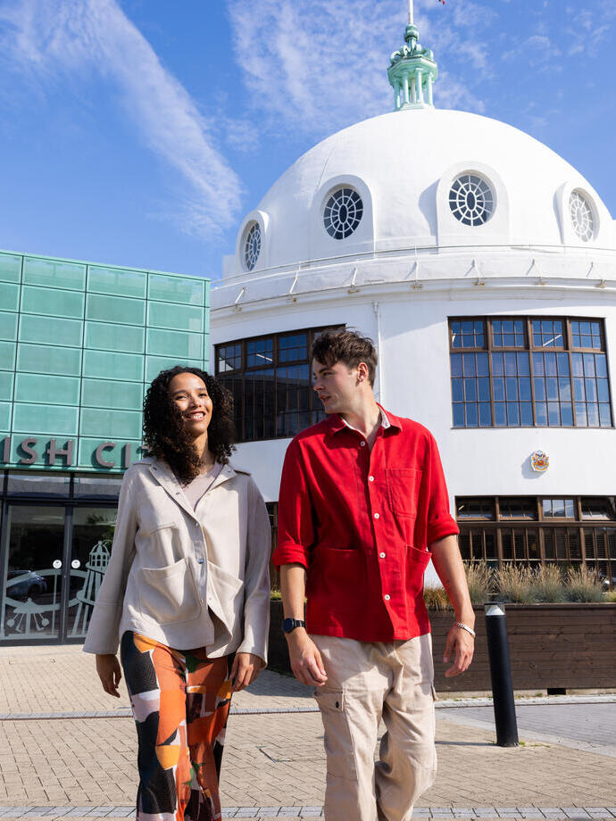 Two friends visiting an old art deco seaside building.
