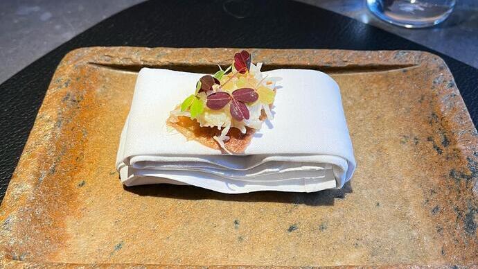 A plate of prepared food sitting on a table in Aulis restaurant, London