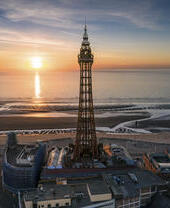 Hoher Turm am Strand mit Sonnenuntergang über dem Meer