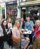Un grupo de personas comiendo y bebiendo en una mesa al aire libre en Cosmo, Cardiff