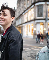 Young man and woman exploring city streets with shops in background