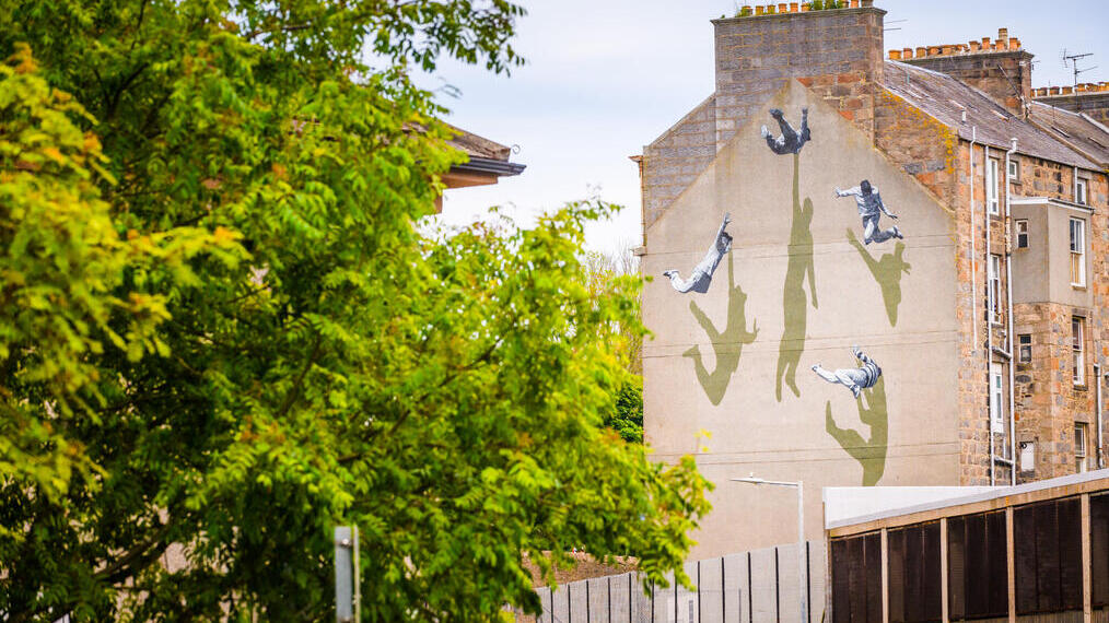 A street art mural on the side of a house.