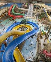 People riding slides at an indoor water park.