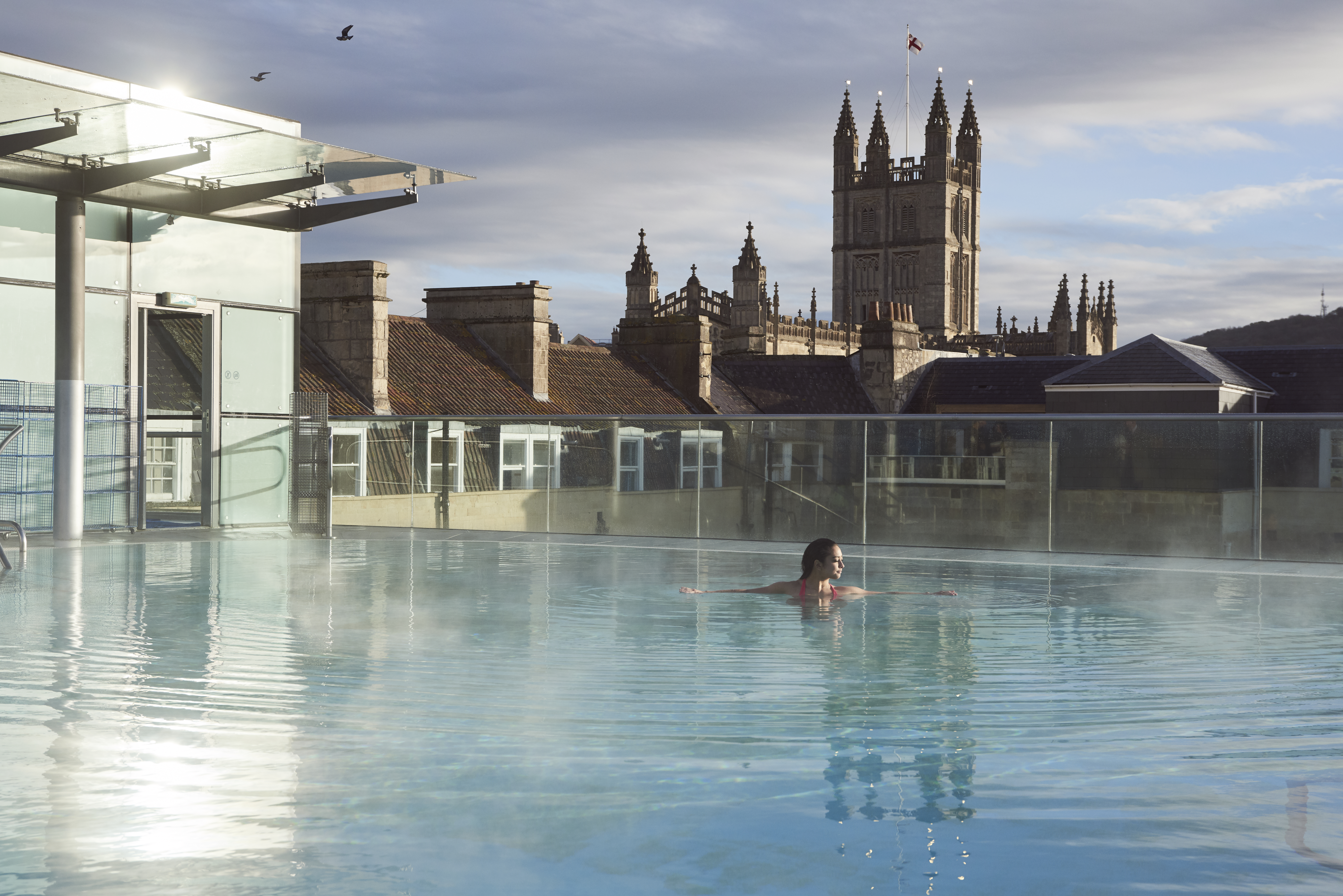 Woman in a roof top swimming pool at a spa