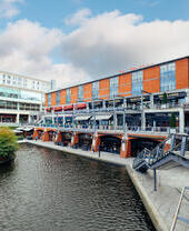 Red brick building next to tall office building beside canal