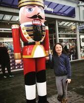 Une fille au Bridgend Designer Outlet à côté d'une statue représentant un soldat de plomb