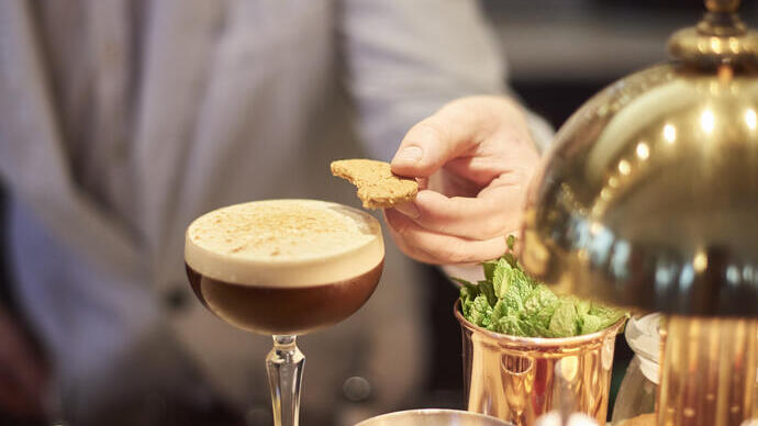 Barkeeper legt Shortbread auf einen Espresso-Martini-Cocktail