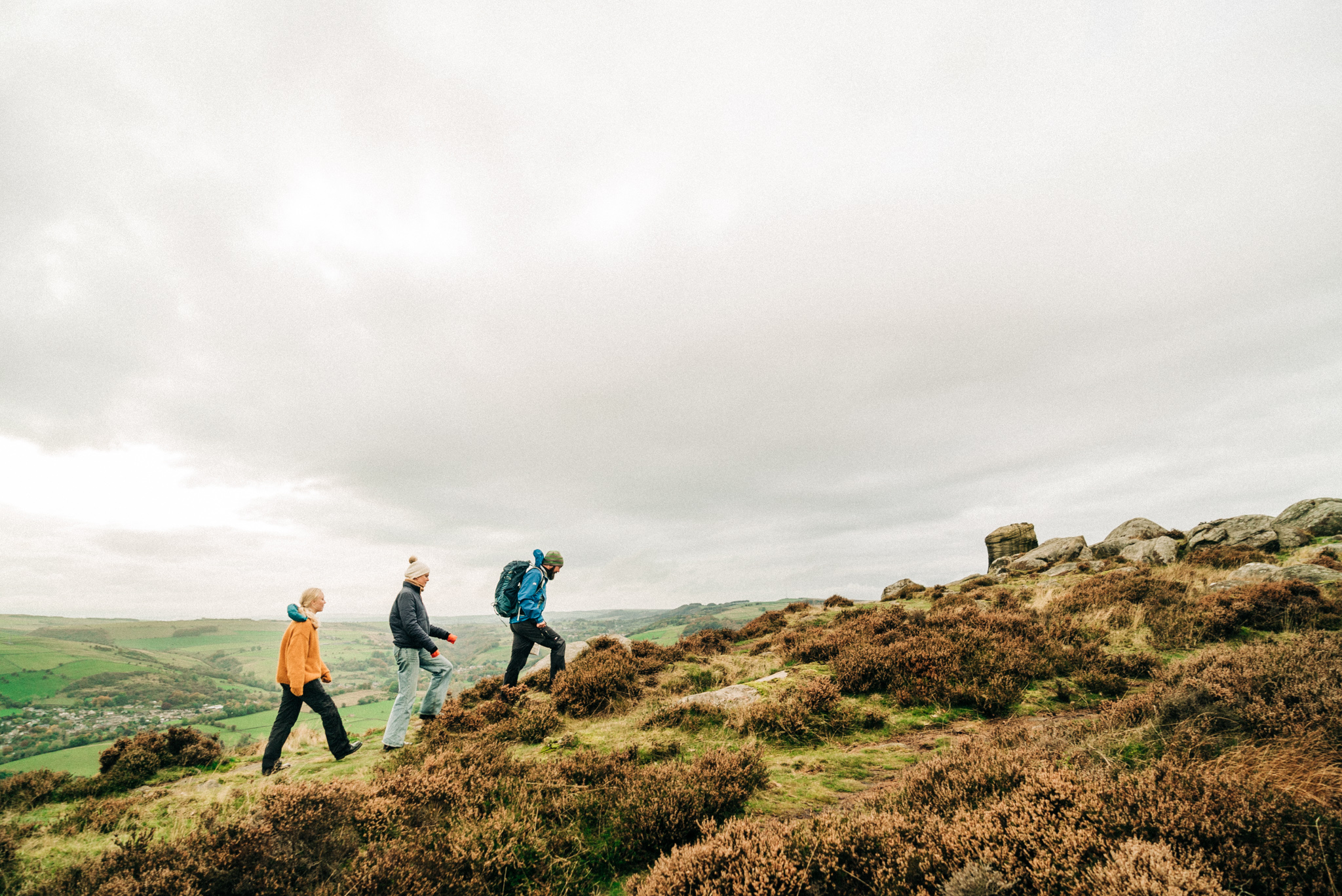 Three people, a man and two women walking up a ridge