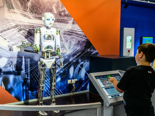 A child playing with an interactive exhibit at a science museum.