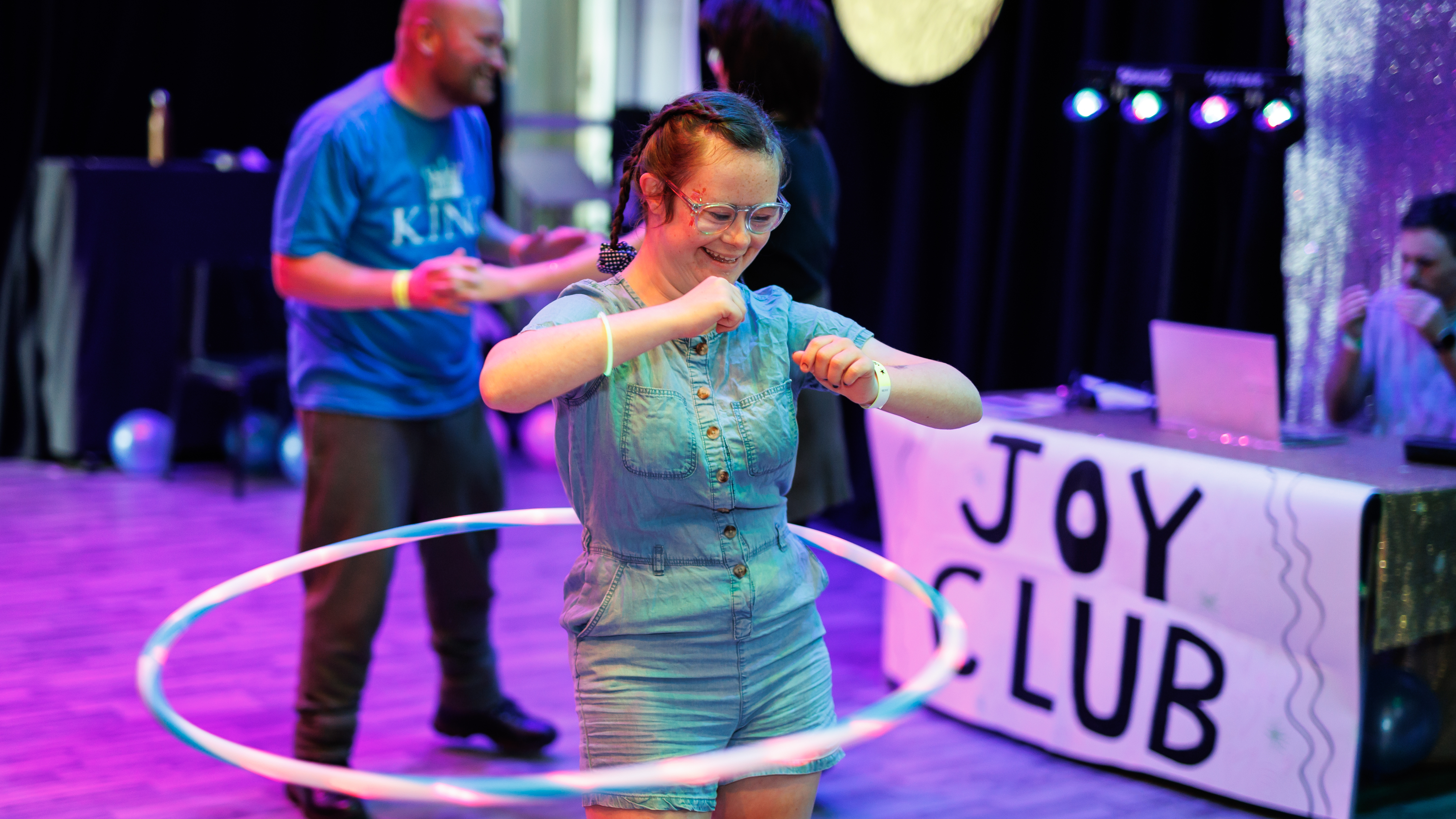A lady dancing with a hula hoop at a centre for the arts.