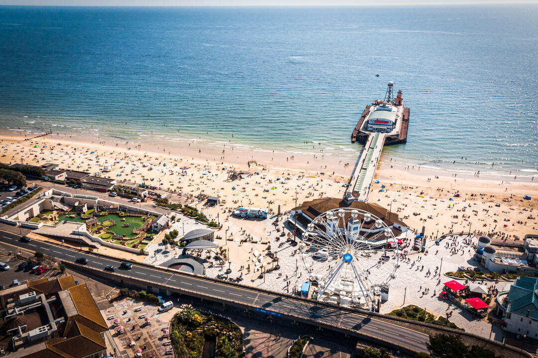 Aerial view of Bournemouth Pier looking out to sea with beach full of people