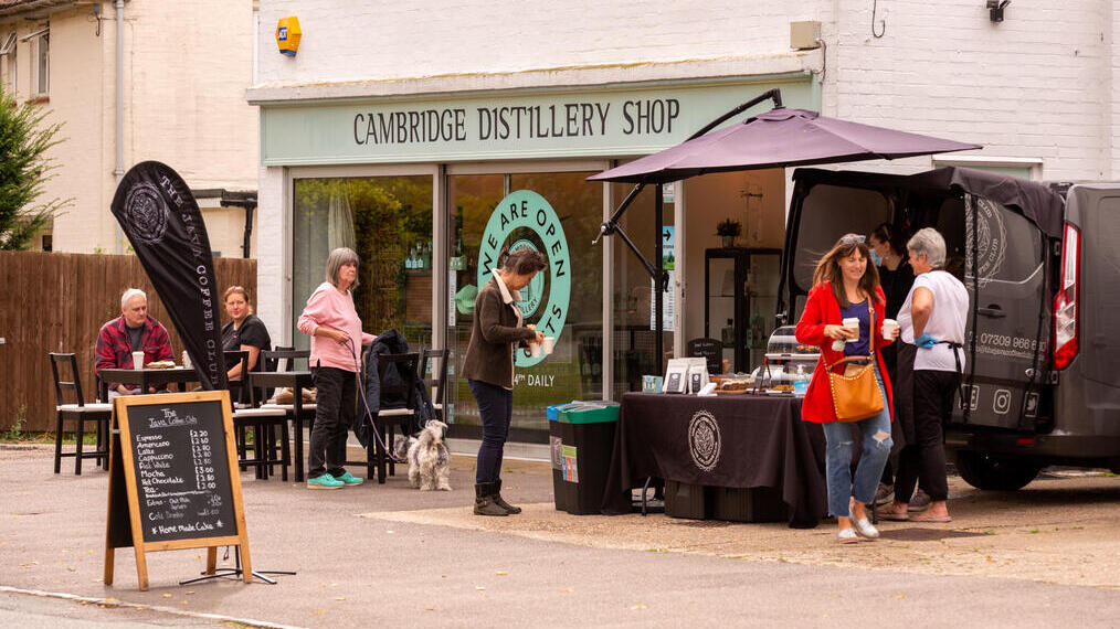 People outside shop with sign reading: Cambridge Distillery Shop