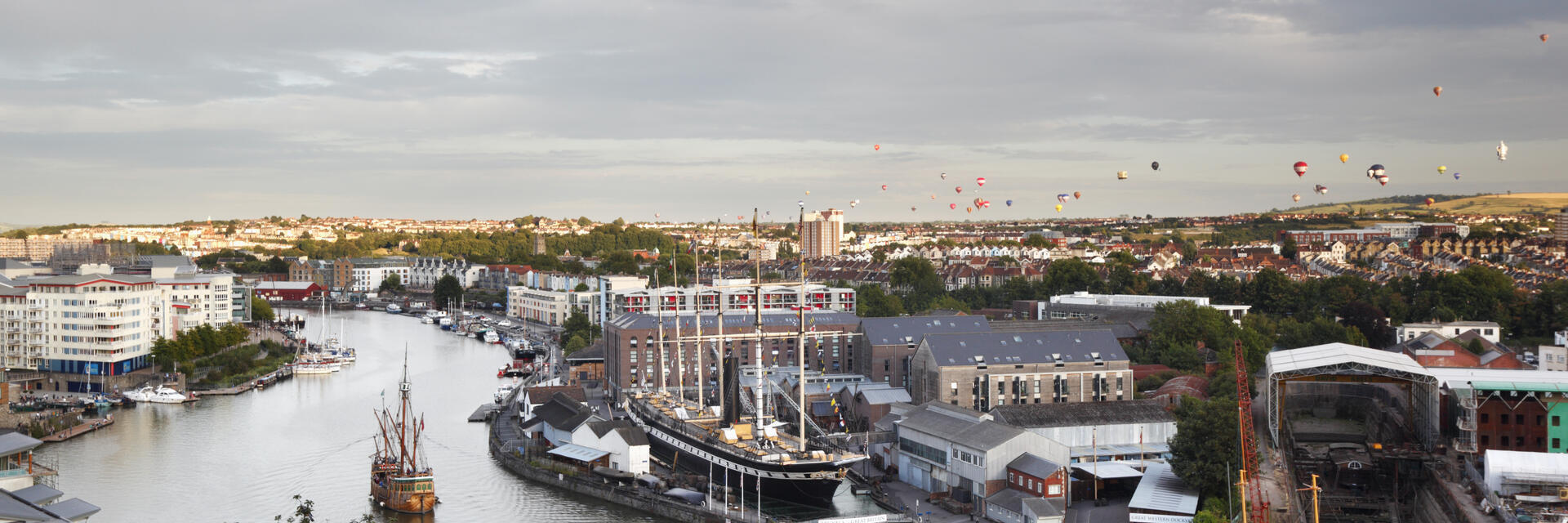 Cityscape showing boats and hot air balloons 