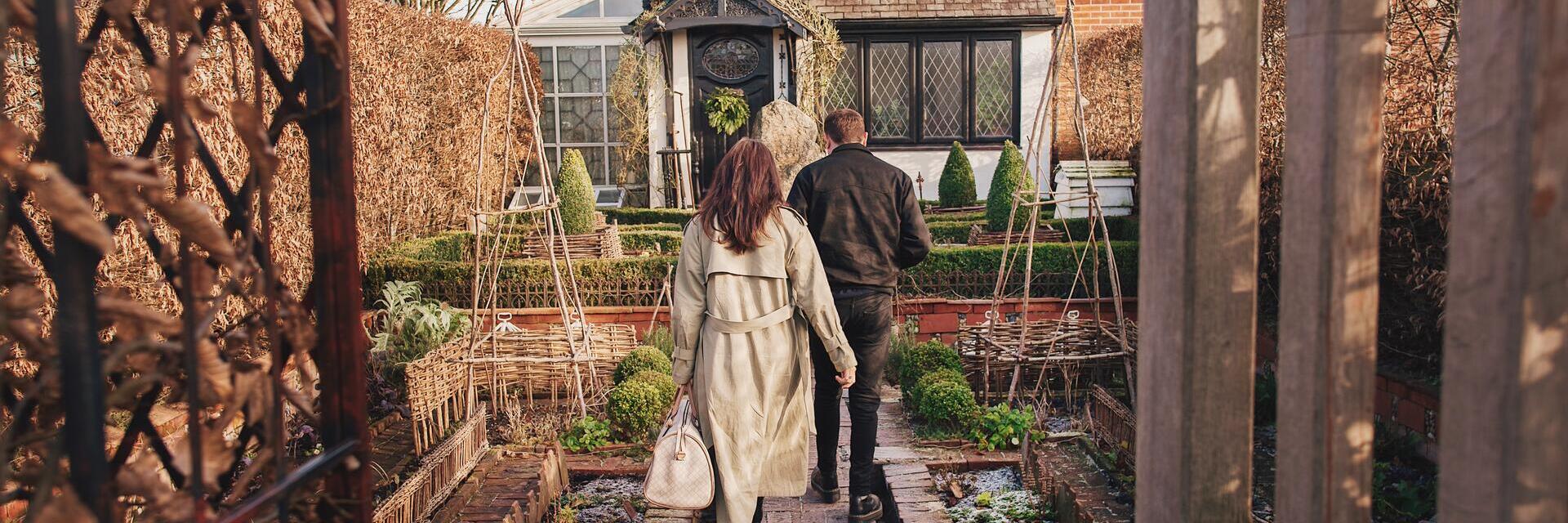 Man and woman walking towards a house