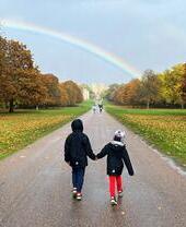 A couple walking towards Windsor Castle on the Long Walk in the Great Park