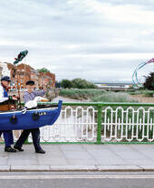 Paar in Kostümen, das über eine Brücke geht