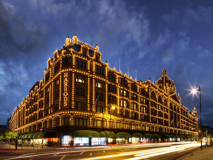 Harrods department store lit up at night. Dark skies