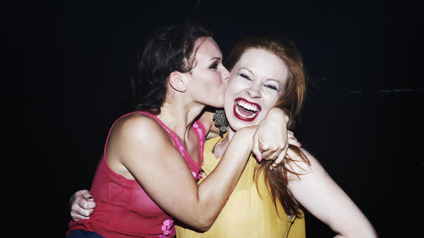 Two women smiling and hugging