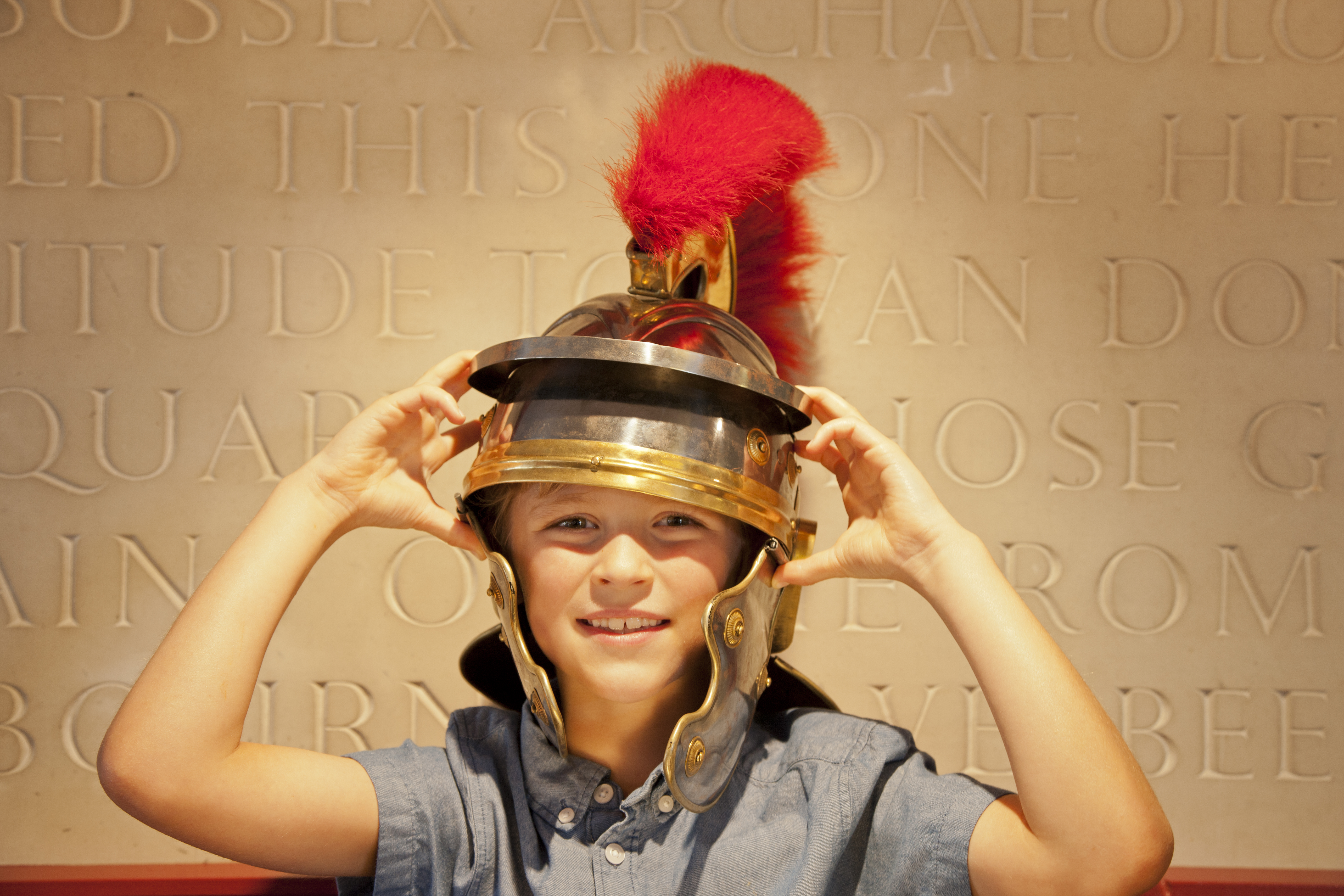 Niño con un casco de centurión romano con una pluma roja