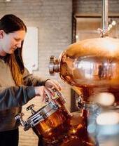 Woman looking at equipment at The Welsh Wind Distillery