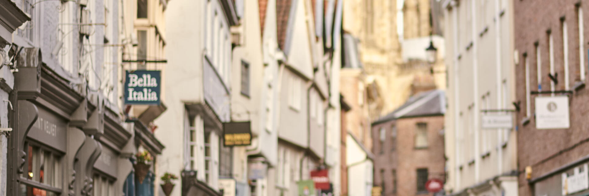 Frau, die durch eine enge historische Straße in einer Stadt geht