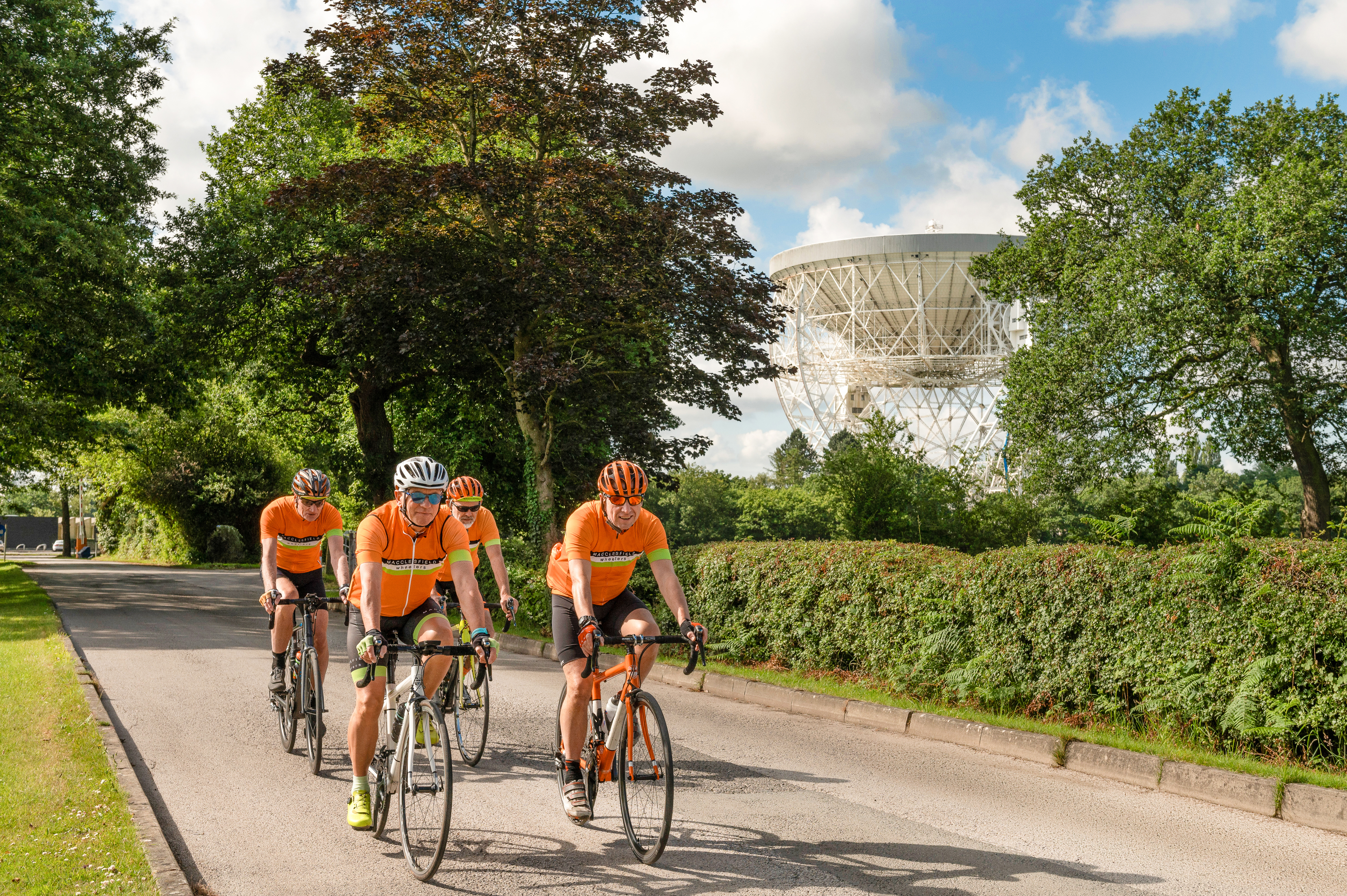 Un grupo de ciclistas pasa por Jodrell Bank.