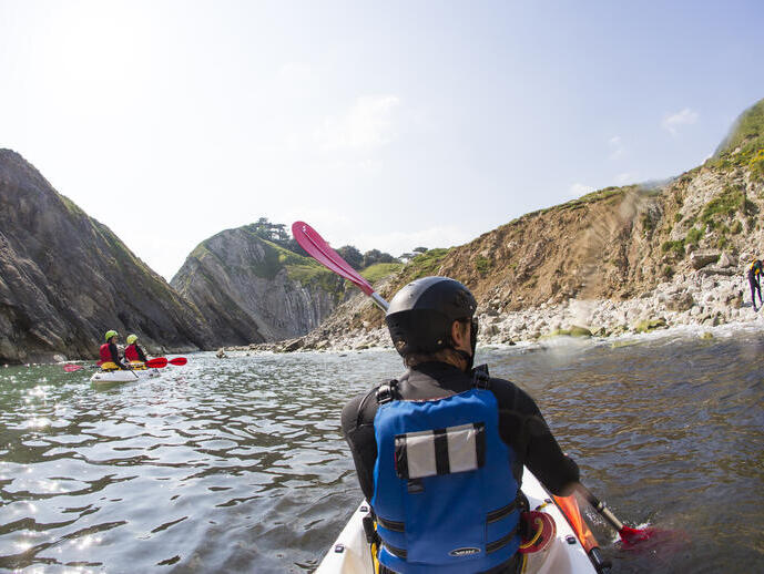 People kayaking along the shores of coastline