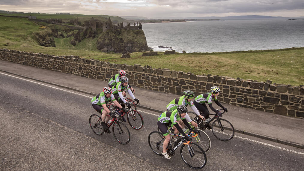 Group of people cycling on a seaside road