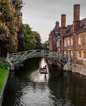 Una sola barca pasa bajo el puente Mathematical, en Silver Street, Cambridge, a última hora de una tarde de verano