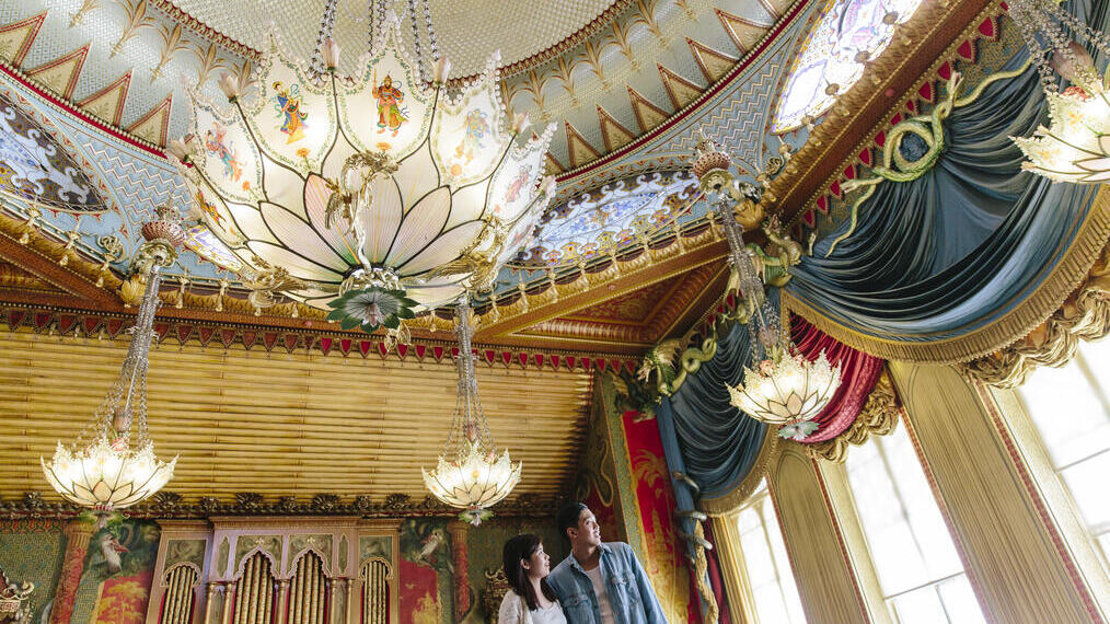 Couple standing in the state banqueting hall of a palace
