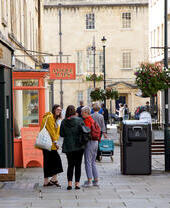 Groups of people walking down a street in Bath's Upper City