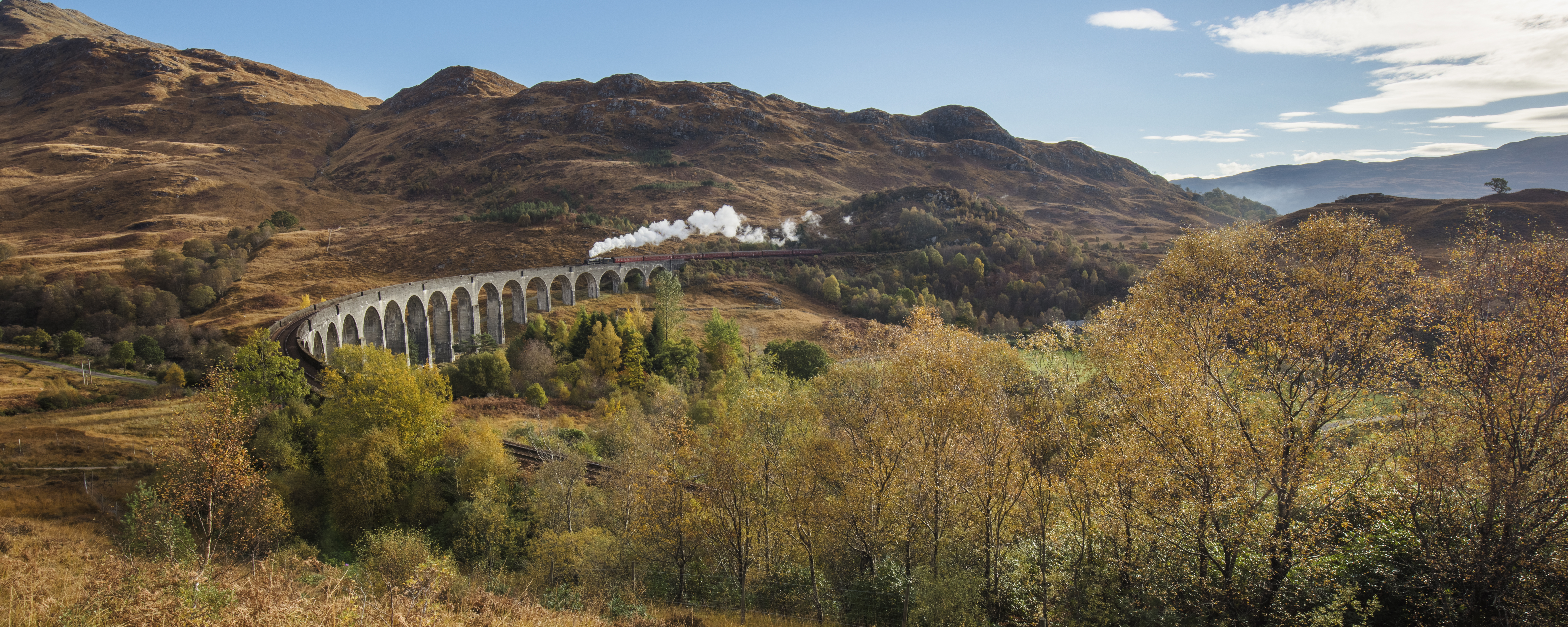A steam train on the Glenfinnan viaduct, a historic viaduct crossing over the valley at Glenfinnan.