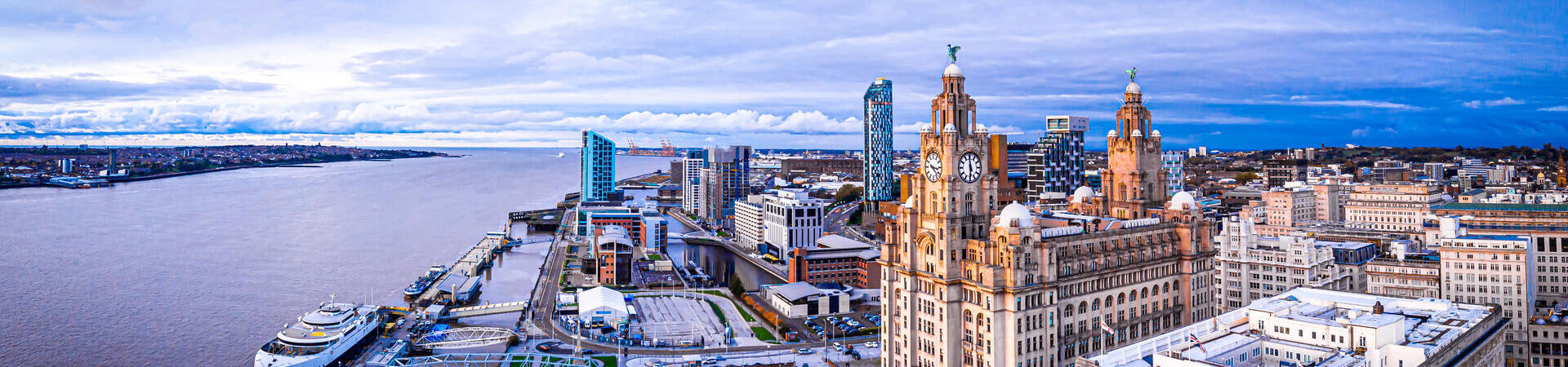 An aerial view of large city buildings overlooking a wide river.