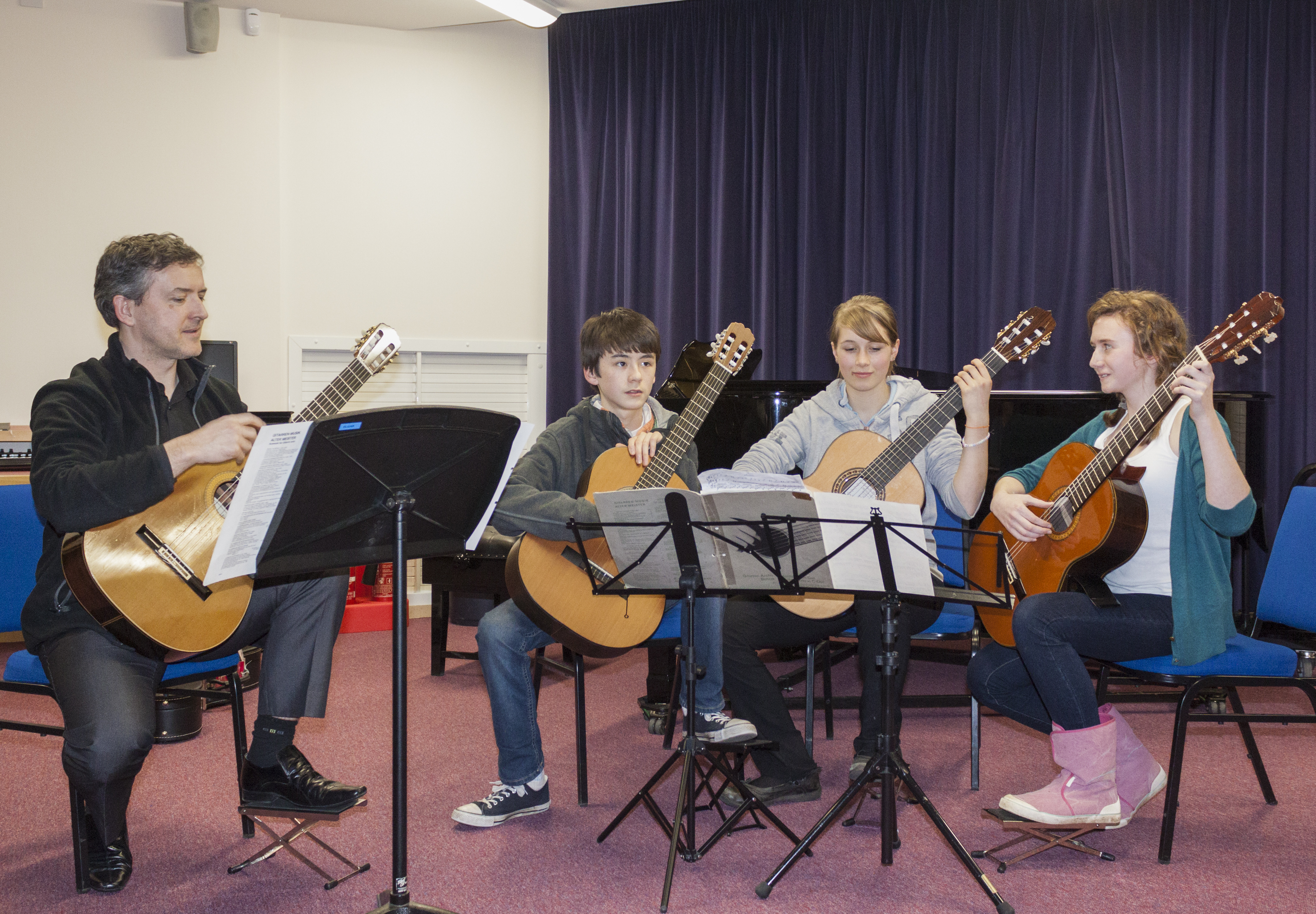 A group of people preparing to play guitars on stage as part of Oxford Music Festival