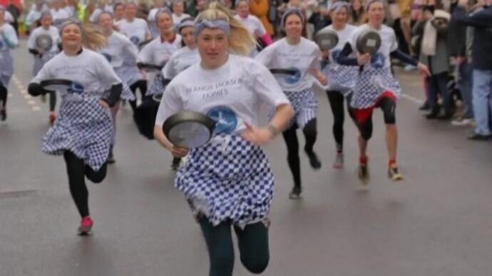 Persone che partecipano alla corsa dei pancake di Olney